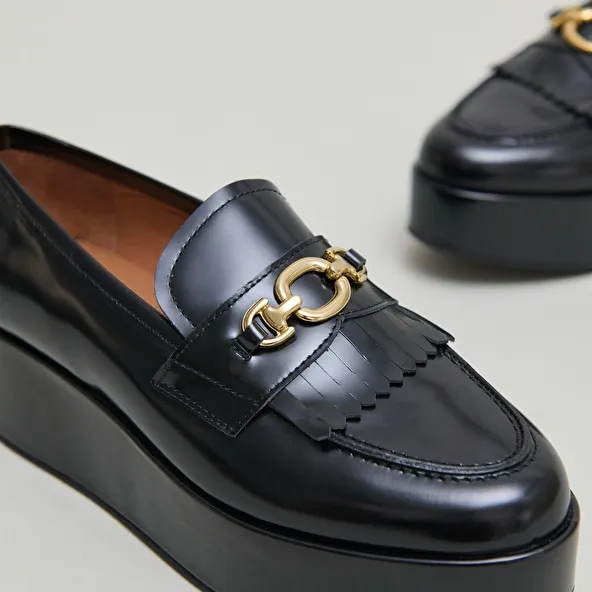 Gold buckle loafers in black glazed leather