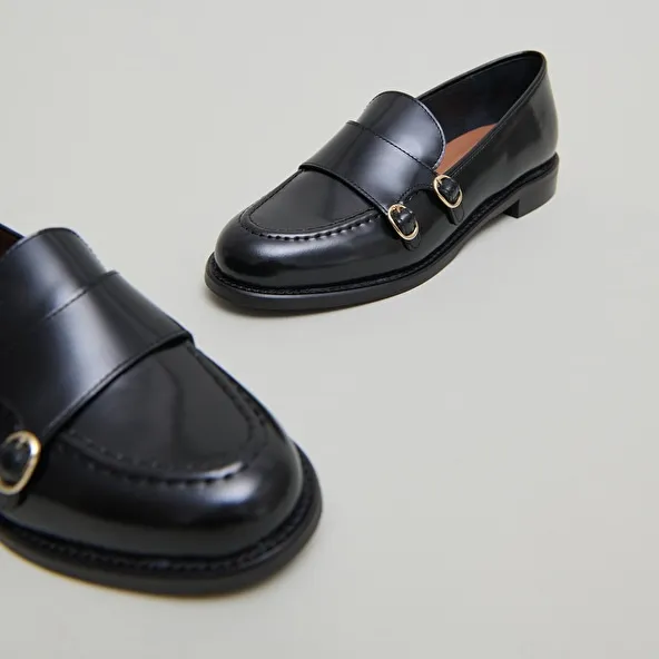 Loafers with adjustable buckles in black glazed leather